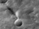 Image en noir et blanc montrant un tourbillon de poussière martien projetant une ombre sur une plaine cratérisée, observé par la caméra CaSSIS de l’orbiteur ExoMars TGO de l’ESA.