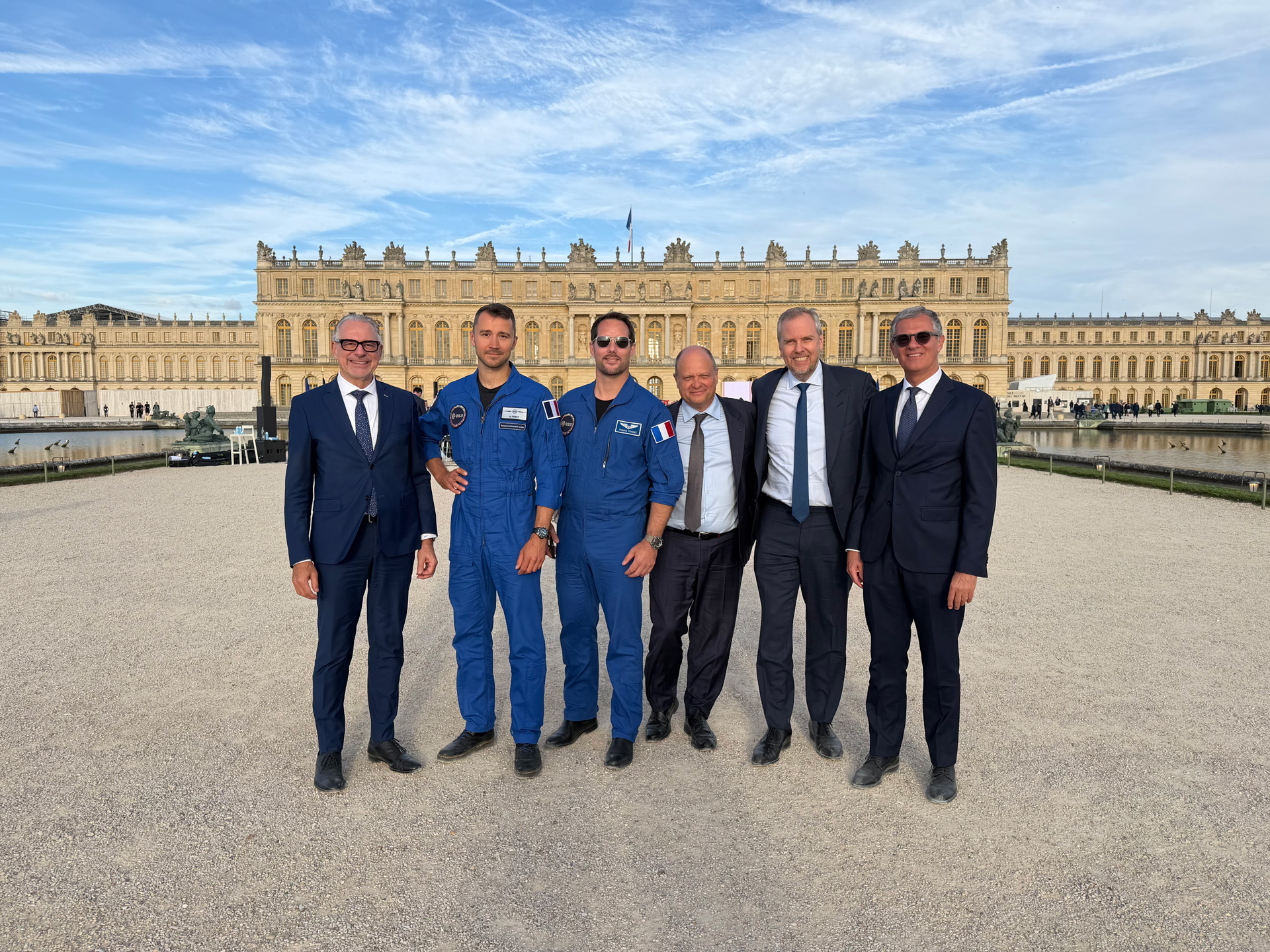 Photo de groupe réunissant Thomas Pesquet, Arnaud Prost, des responsables de l’ESA, du CNES et de Vast devant le château de Versailles lors du sommet Choose France 2026.